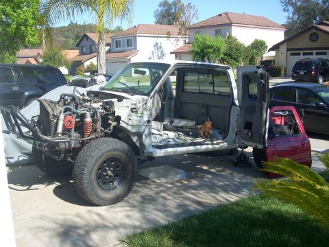 1992 Ford Ranger - A pickup truck is disassembled in a driveway, with its engine and front end removed for work.