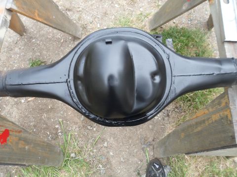 1991 Ford Bronco - A black rear axle differential assembly is shown resting on wooden sawhorses outdoors.