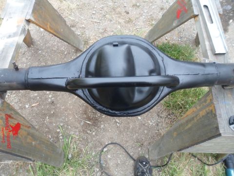 1991 Ford Bronco - Rear axle differential housing sits on sawhorses, with a "Genuine Burro Brand" logo on the wood.