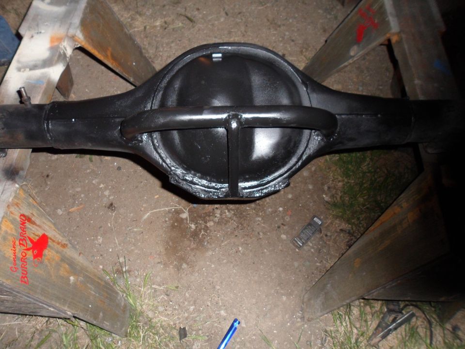 black rear axle differential assembly on wooden sawhorses, with text on wood reading 'Genuine Burro Brand'