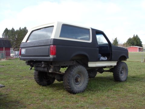 1988 Ford Bronco - This 1987 Ford Bronco features a two-tone paint scheme and significant suspension lift, suggesting off-road modifications.