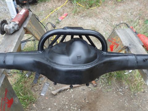 1991 Ford Bronco - A black Ford rear axle assembly, possibly modified with a roll cage hoop, is shown outdoors on sawhorses.