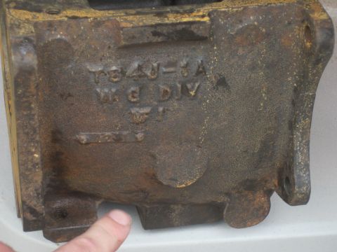 1979 Ford Bronco - A close-up view of a weathered, cast iron component with visible stamped lettering and raised lettering.