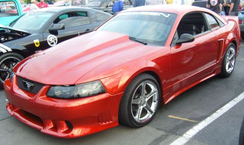 2007 Ford Mustang - Front three-quarter view of a red SN-95/New Edge Ford Mustang coupe with a Saleen body kit, front fascia with brake ducts, side scoops, roc…
