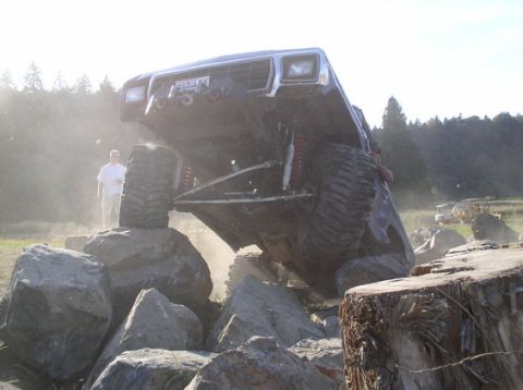 1979 Ford Bronco - A modified off-road vehicle navigates a challenging rocky terrain with a person observing the action.