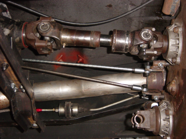 Driveshaft with double-cardan U-joints at transfer case output, muffler alongside