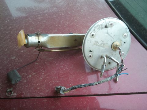 1998 Ford Crown Victoria - A disassembled fuel pump assembly rests on a car's trunk lid.