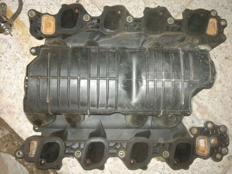1998 Ford Crown Victoria - Close-up of a black engine intake manifold, likely a replacement part.