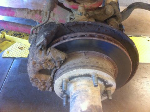 1990 Ford Bronco - Close-up of a heavily corroded front wheel hub and brake assembly, likely from an older truck or SUV.