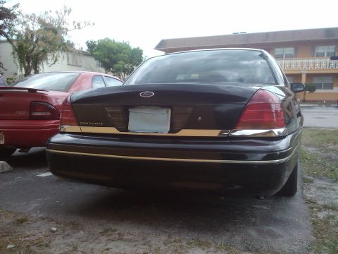 2001 Ford Crown Victoria - Rear view of a black 2001 Ford Crown Victoria LX, showing its distinctive taillights and chrome accents.