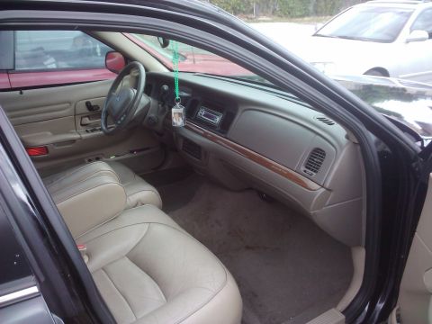 2001 Ford Crown Victoria - Interior view of a 2001 Ford Crown Victoria, showing the dashboard, seats, and a glimpse of other vehicles outside.