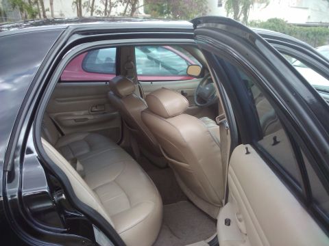 2001 Ford Crown Victoria - Interior view of a black sedan, revealing tan upholstery on the rear and front seats.