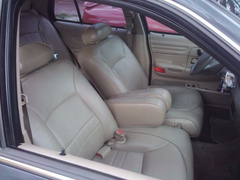 2001 Ford Crown Victoria - The interior of a 2001 Ford Crown Victoria features tan leather seats and a center console armrest.