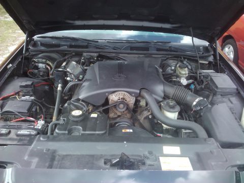 2001 Ford Crown Victoria - Engine bay view of a 2001 Ford Crown Victoria, with another vehicle partially visible to the right.