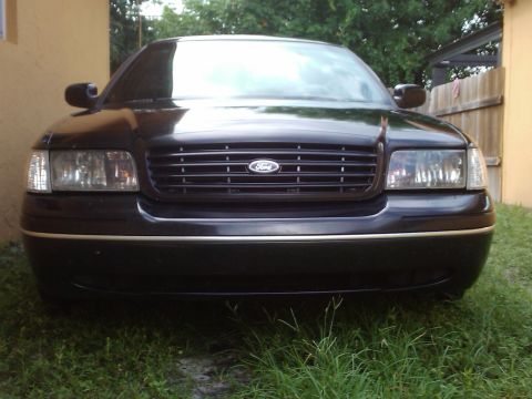 2001 Ford Crown Victoria - Front view of a black 2001 Ford Crown Victoria with a prominent grille and chrome bumper accents.