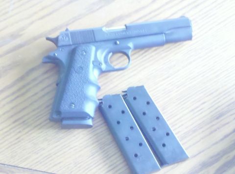 1988 Chevrolet Suburban - Pistol and two magazines on a wooden table.