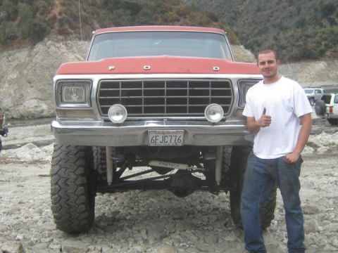 1978 Ford Bronco - A man gives a thumbs up next to a red 1978 Ford Bronco with off-road modifications.
