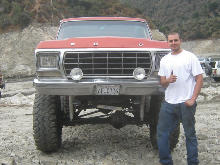 Red 1978 Ford Bronco with lifted suspension and large tires, front view