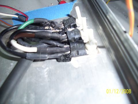 1995 Ford Probe - The image shows a close-up of damaged electrical wiring and connectors, with evidence of melting and poor repair.