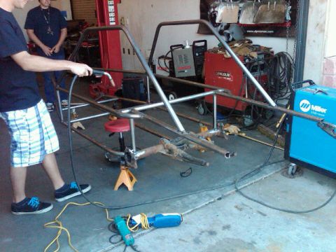 1995 Ford F-150 - A metal frame is being worked on in a garage setting with welding equipment visible.