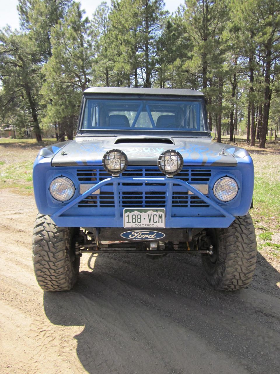 Blue Ford Bronco with off-road lights and bumper, front view