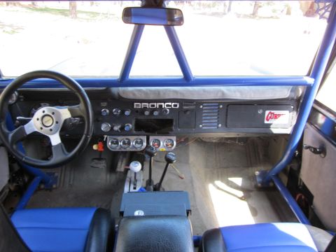 1971 Ford Bronco - The interior of a 1971 Ford Bronco shows a blue roll cage and custom dashboard with "BRONCO" badging.