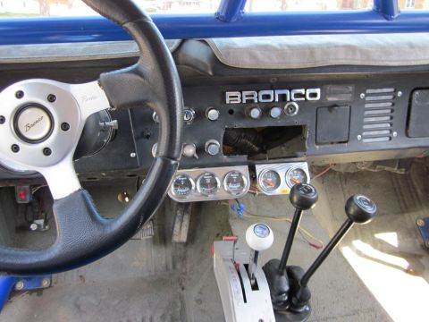 1971 Ford Bronco - The dashboard of a 1971 Ford Bronco shows the 'BRONCO' emblem and several aftermarket gauges.
