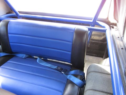 1971 Ford Bronco - Interior view of a vehicle with blue seats and a roll cage.
