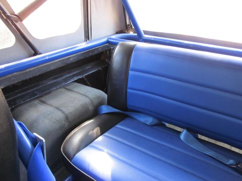 1971 Ford Bronco - The interior of a vehicle features blue vinyl seats and a roll cage, with a watermark for Supermotors.net visible.