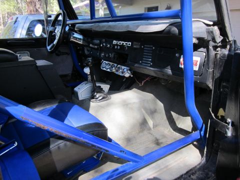 1971 Ford Bronco - The interior of a 1971 Ford Bronco features a prominent blue roll cage and custom racing seats.