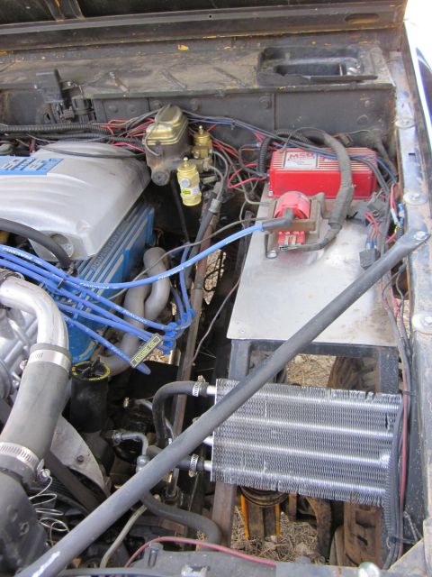 1971 Ford Bronco - The engine bay of a vehicle shows a V8 engine with aftermarket ignition and cooling components.