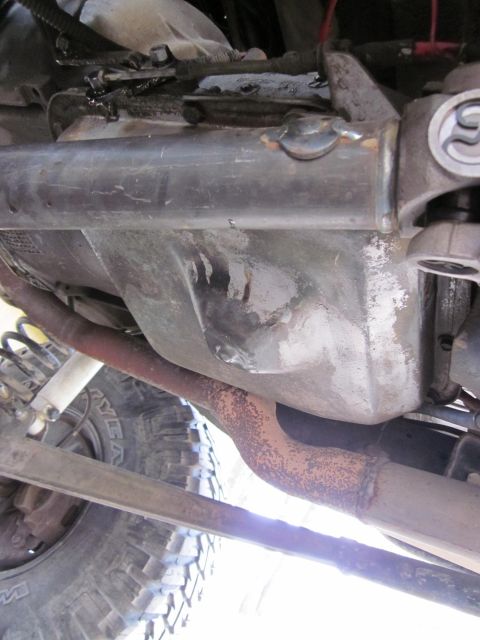 1971 Ford Bronco - Close-up view of the undercarriage of a vehicle, revealing mechanical components and signs of wear.