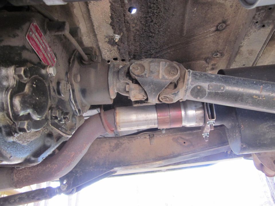 Underbody view of drivetrain and exhaust system with a red tag on the transmission