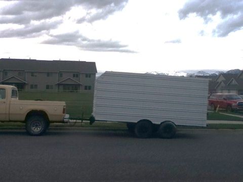 2006 Ford E350 - Pickup truck tows a large white cargo trailer down the road.