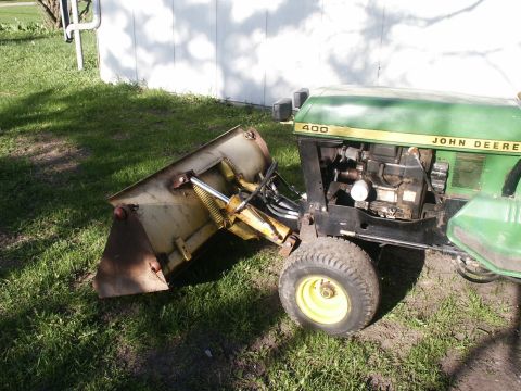 1966 Ford Bronco - A green John Deere 400 tractor equipped with a front loader is parked on a grassy area.