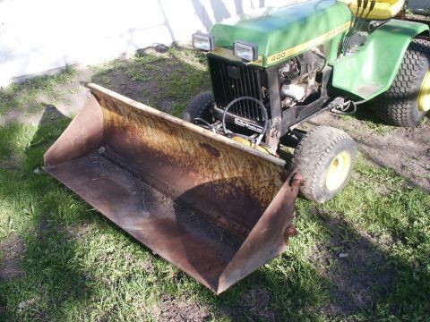 1966 Ford Bronco - A John Deere 400 tractor is equipped with a front loader, ready for yard work.