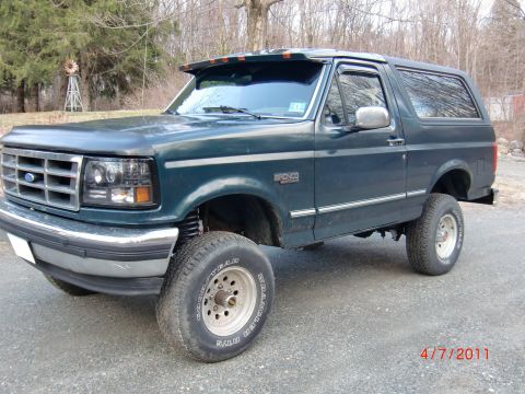 1993 Ford Bronco - A lifted 1993 Ford Bronco is shown from a three-quarter front angle.