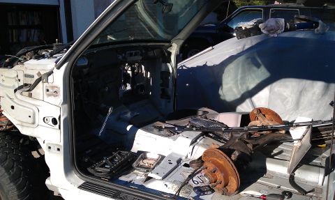 1992 Ford Ranger - The interior of a disassembled truck is visible, with parts scattered around and another vehicle in the background.
