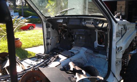 1992 Ford Ranger - The interior of a white truck is shown with its dashboard and many components removed, revealing the underlying structure.
