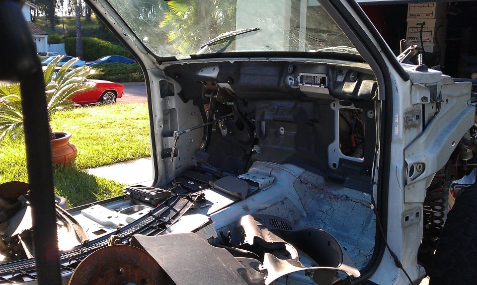 Disassembled white truck interior with dashboard removed