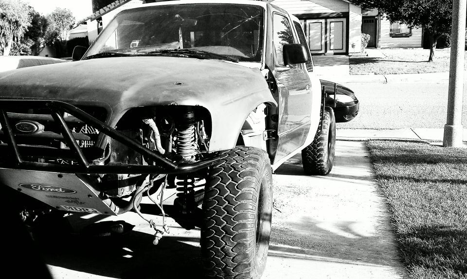 1992 Ford Ranger truck with off-road modifications, front bumper removed, exposed engine components, and large tires