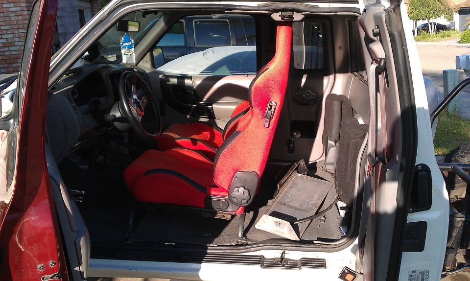 Interior of a truck with red racing seats and a roll cage