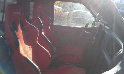 1992 Ford Ranger - Vehicle interior red Sparco racing seats and a steering wheel.