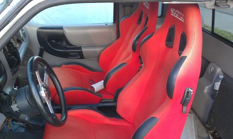 1992 Ford Ranger - The interior of a vehicle is shown, bright red racing seats and a custom steering wheel, suggesting aftermarket modifications.