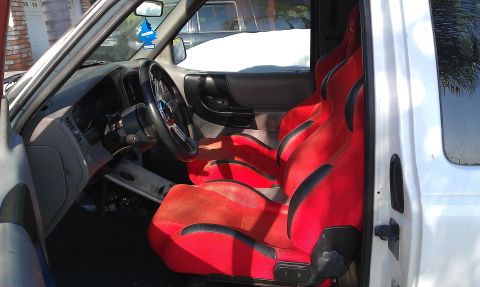 1992 Ford Ranger - The interior of a truck is shown, bright red racing seats and a custom steering wheel.