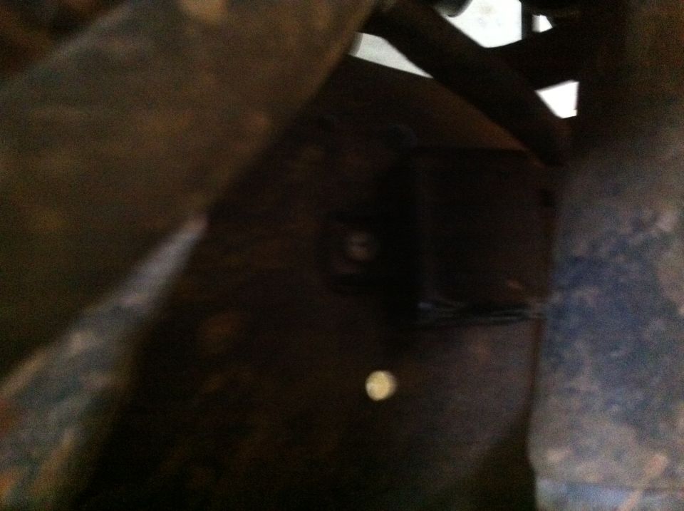 close-up of rusty vehicle frame and suspension parts, with a 'SUPERMOTORS' watermark