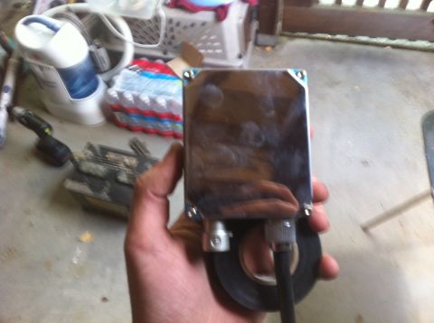 1990 Ford Bronco - A chrome-plated electronic component is held in a hand, with wires and tape attached.