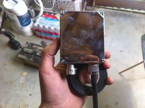 1990 Ford Bronco - A person is holding a chrome-plated electronic component with electrical tape wrapped around a connector.
