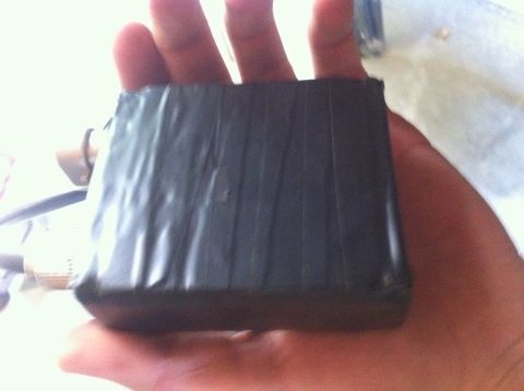 1990 Ford Bronco - A hand holds a dark object wrapped in black tape.