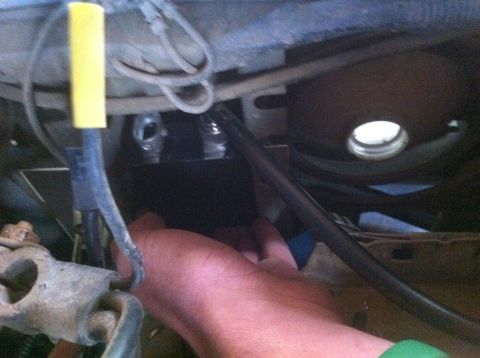 1990 Ford Bronco - Close-up view of various mechanical parts and wiring in a vehicle's engine compartment.